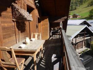 a wooden table on the balcony of a cabin at Appartement Arêches-Beaufort, 3 pièces, 5 personnes - FR-1-342-297 in Beaufort