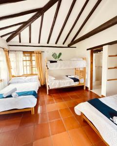Zimmer mit 3 Betten und einer Decke in der Unterkunft Lo Nuestro - Hospedaje in Villa de Leyva