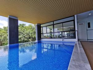 uma piscina de beiral infinito numa casa com uma grande janela em VIP Great Hill em Thalang