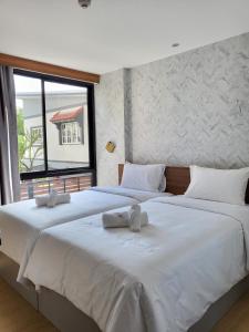 2 grote witte bedden in een kamer met een raam bij S3 Huahin Hotel in Hua Hin