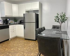 eine Küche mit einem Kühlschrank und einem Tisch mit Stühlen in der Unterkunft Simply Stays in Ottawa
