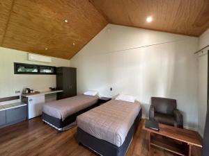 ein Hotelzimmer mit 2 Betten und einem Stuhl in der Unterkunft Hedlow Retreat in Barmoya