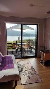 a bedroom with a large sliding glass door with a table at Cabañas Isla Del rey in Valdivia