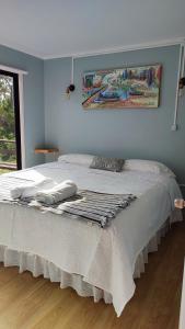 Un dormitorio con una cama con una manta. en Cabañas Isla Del rey, en Valdivia