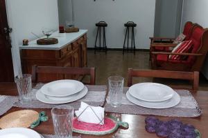 una mesa de comedor con platos y vasos. en Casa em Vila Isabel, en Río de Janeiro