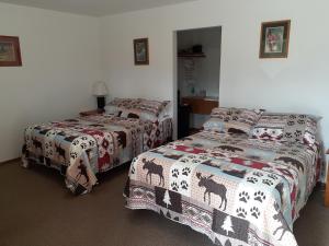 White Moose Lodge في هيلي: سريرين في غرفة مع سريرين sidx sidx
