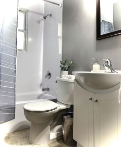 a bathroom with a white toilet and a sink at Simply Stays in Ottawa