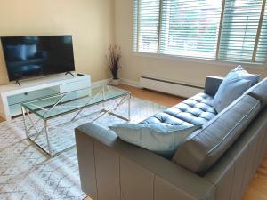 ein Wohnzimmer mit einem Sofa und einem TV in der Unterkunft Simply Stays in Ottawa