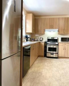 eine Küche mit Holzschränken und einem Kühlschrank aus Edelstahl in der Unterkunft Simply Stays in Ottawa