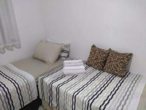 Habitación con 2 camas y sofá con almohadas en Casa em Vila Isabel, en Río de Janeiro