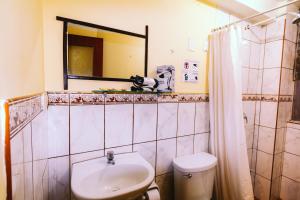 a bathroom with a sink and a toilet and a mirror at T'ika Guest House in Cusco