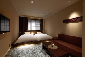 1 dormitorio con 1 cama y 1 sofá en Minn Kanazawa, en Kanazawa