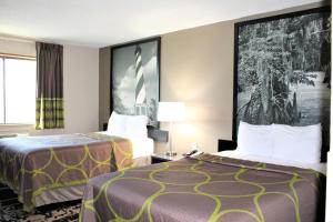 a hotel room with two beds and a window at Super 8 by Wyndham Greensboro/Coliseum/Conv. in Greensboro