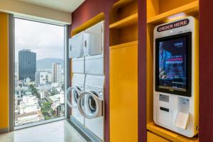 a washing machine in a room with a window at Wink Hotel Danang Centre - 24hrs stay in Danang