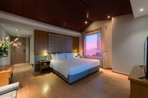 um quarto com uma cama grande e uma janela grande em Le's Cham Hotel em Nha Trang