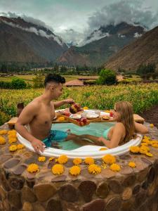 a man and a woman sitting in a hot tub at Inkasaire Boutique Lodge in Urubamba