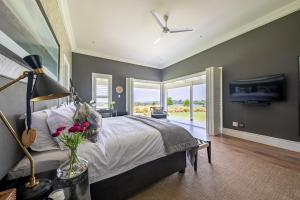 a bedroom with a large bed and a tv at Prestwick-on-Gowrie, Gowrie Farm, Nottingham Road in Nottingham Road