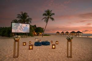 a wedding on the beach with candles and a screen at Cora Cora Maldives - Premium All-Inclusive Resort in Raa Atoll