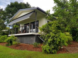 a small house with a porch and a balcony at Eumundi Cottages - Cottage 1 in Eumundi