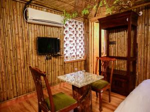 a room with a table and chairs and a tv at Hotel Green Heaven Resort in Pushkar