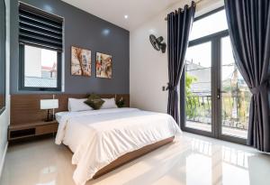um quarto com uma cama grande e janelas grandes em Peaceful House Hostel em Dong Hoi