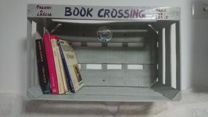 un estante con libros encima de una señal de cruce de libros en Casa Lucia, en Vieste