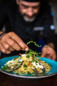 a man eating a plate of pasta with seafood at Breakas Beach Resort in Port Vila