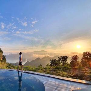 um homem no topo de uma piscina de beiral infinito com vista para a montanha em BAKHAN VIEWEST GLAMPING em Mai Châu