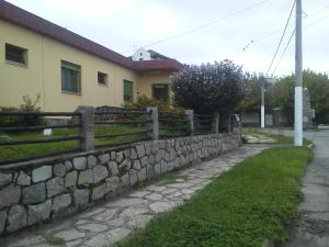 a stone retaining wall in front of a house at La Casa de Ramatis in Valle Hermoso