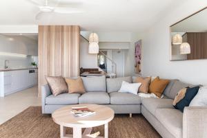 una sala de estar con un sofá y una mesa en Noosa Crest Penthouse 37 - Private Rooftop Pool, en Noosa Heads