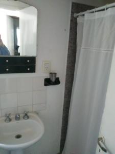Baño blanco con lavabo y espejo en Casa Balneario Orense en 