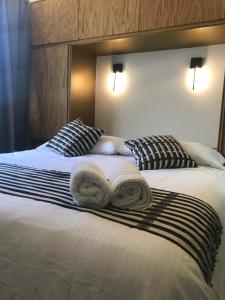 two towels on a bed with two pillows at CASA LALIQUE in Mexico City