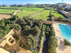 uma vista aérea de uma villa com uma piscina e árvores em Newly Converted One of a Kind Farmhouse Villa In Gozo em Għarb