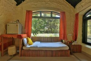 a bed in a room with a window at Bison Retreat - Pench 