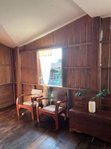 a room with a table and chairs and a window at BUA Homestay : cozy house in Laplae district in Uttaradit