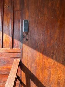 a wooden door with a cell phone on it at BUA Homestay : cozy house in Laplae district in Uttaradit