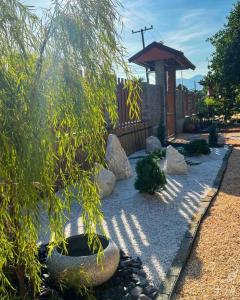 un giardino con rocce, un albero e un gazebo di BUA Homestay : cozy house in Laplae district a Uttaradit