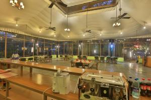 a large room with tables and chairs and a room with at Bison Retreat - Pench 