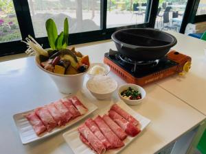 un mostrador con dos platos de carne y una parrilla en 山水妍溫泉會館-台東館, en Taimali