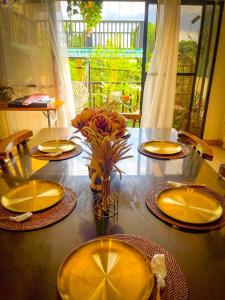 d'une table à manger avec des assiettes jaunes et des fleurs. dans l'établissement Unique Vacation Home in Tagaytay with Pool, à Tagaytay