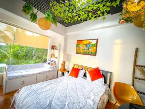 - une chambre avec un lit doté d'oreillers rouges et une fenêtre dans l'établissement Unique Vacation Home in Tagaytay with Pool, à Tagaytay