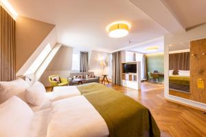 ヴァイセンフェルスにあるParkhotel Güldene Bergeのベッドとリビングルームが備わるホテルルームです。