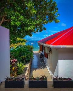 a house with a red roof and some plants at Villa KER IGUANE Terre de Haut Les saintes in Terre-de-Haut