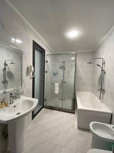 a bathroom with a tub and a sink and a shower at Deluxe Ferghana Hotel in Fergana