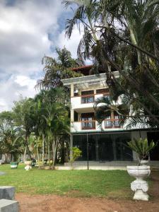 a building with palm trees in front of it at Amani Lake Resort in Moratuwa