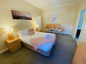 1 dormitorio con 1 cama, mesa y sillas en Settlers House York, en York