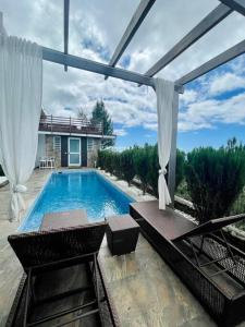 a swimming pool with white curtains and a patio at Suite by the Pool in Faaa