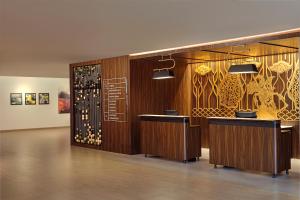 a restaurant with two counters and a wall with paintings at ARTOTEL Batam in Batam Center