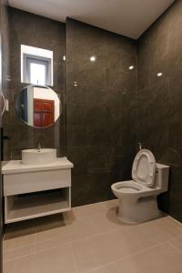 La salle de bains est pourvue de toilettes, d'un lavabo et d'un miroir. dans l'établissement Cassie Boutique Hotel, à Vung Tau
