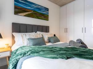 a bedroom with a large bed with a green blanket at Luxury Accomodation at the Alphen Glen in Cape Town